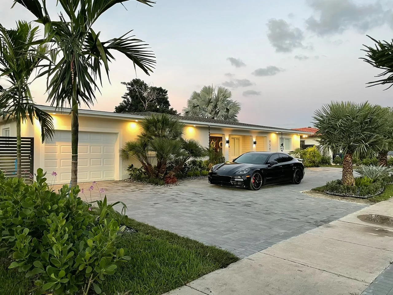 Charcoal paver driveway at dusk in front of a white house, Miami, FL