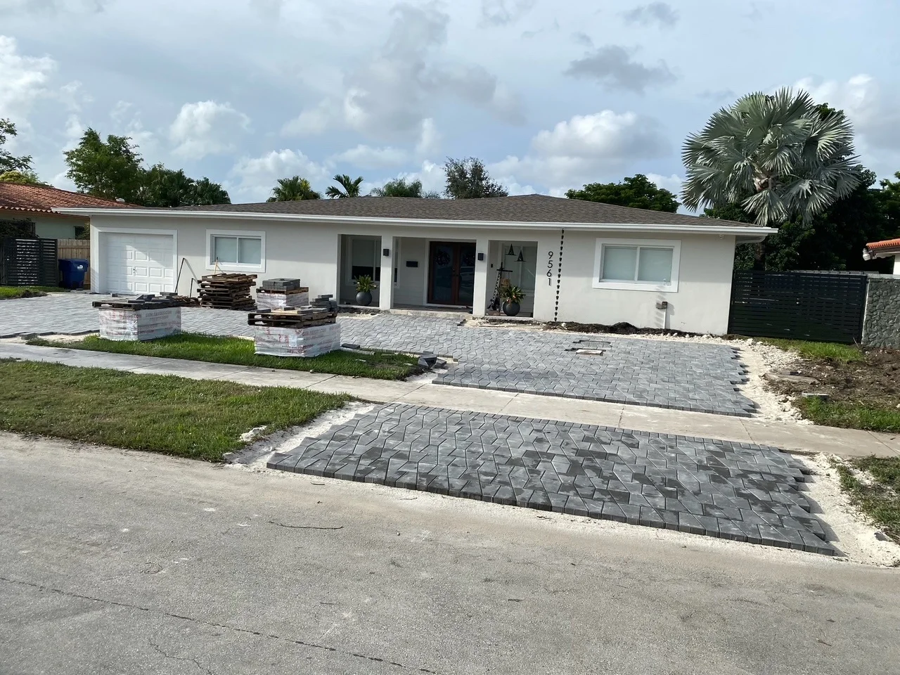 Charcoal pavers being laid across a driveway in front of a house, Miami, FL