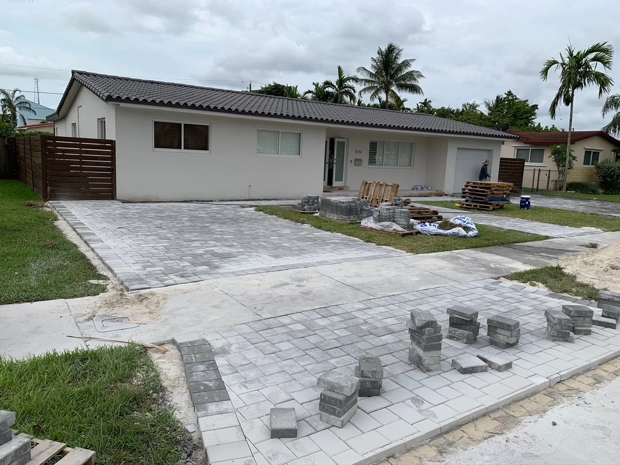 Stacks of charcoal pavers staged across a half-laid driveway, Miami, FL