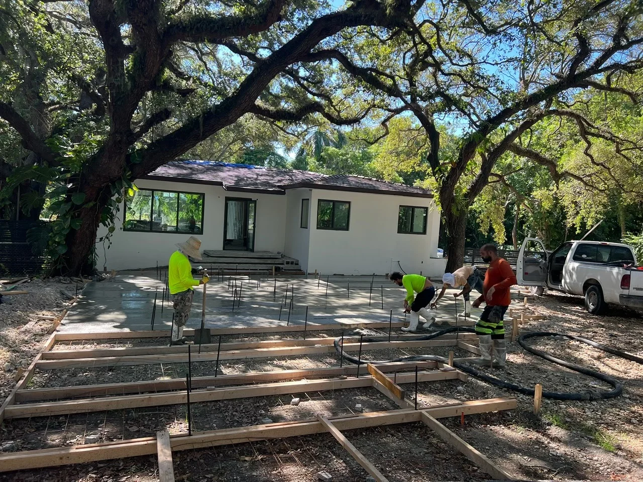 Crew setting forms for a concrete driveway under the trees, Miami, FL