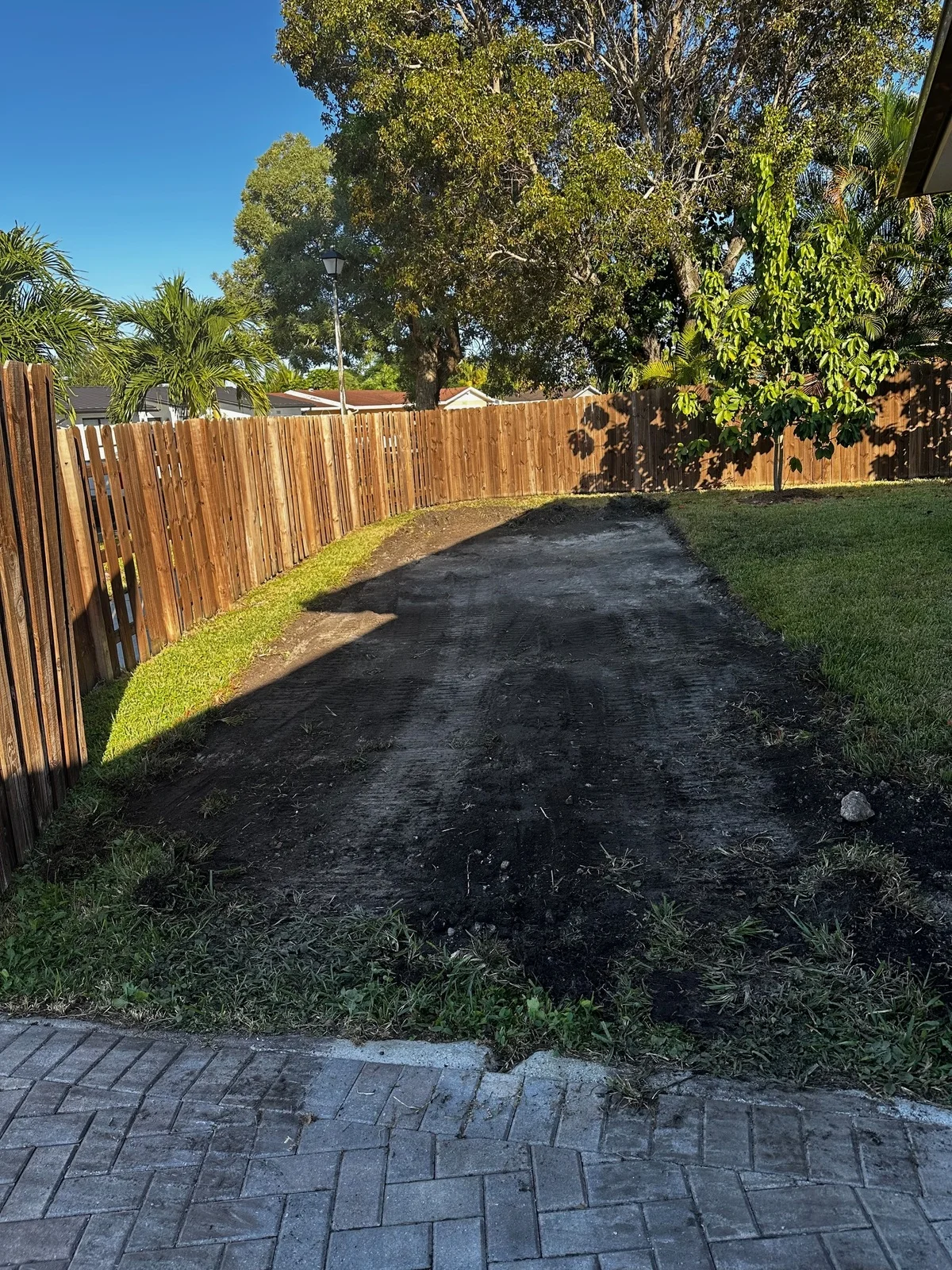 Bare dirt strip along the side of a house before a concrete pad was poured, Miami, FL