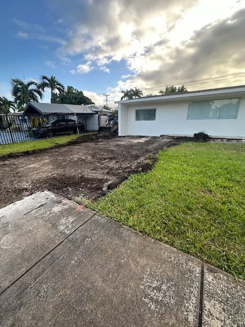 Driveway strip excavated beside the lawn ahead of the paver base, Miami, FL
