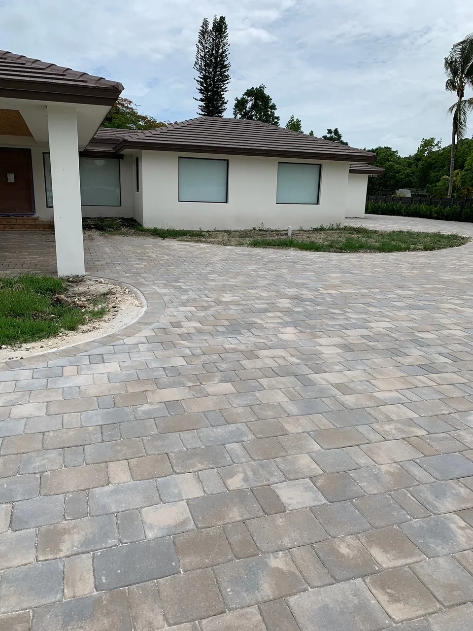 Paver driveway curving around a planted island toward the front entry, Miami, FL