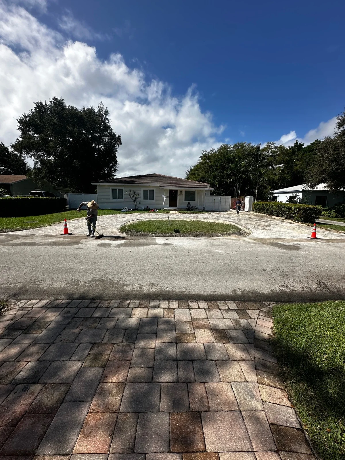 New pavers being laid at the driveway edge with cones out at the street, Miami, FL