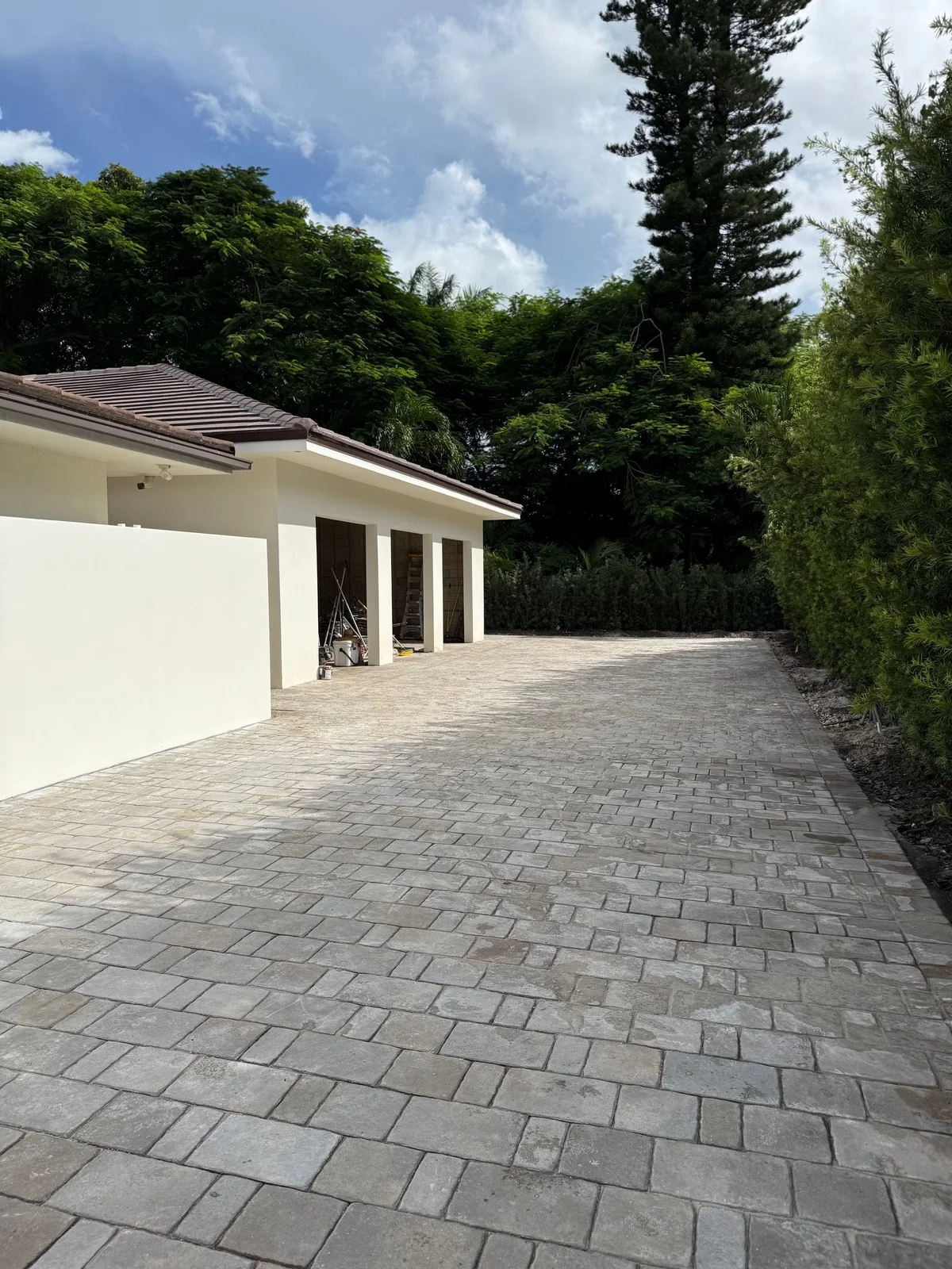 Paver drive to the garage doors with a clipped hedge along one side, Miami, FL