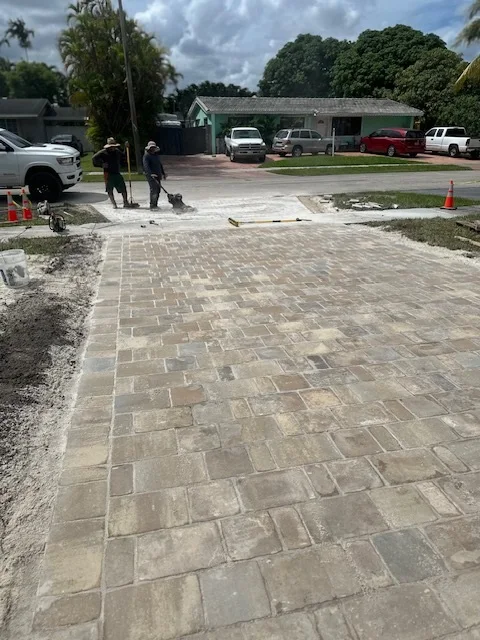 Pavers going down toward the street while the crew runs the compactor behind, Miami, FL