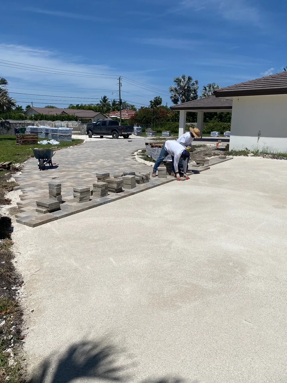 Crew laying the outer course of a wide paver driveway, Miami, FL