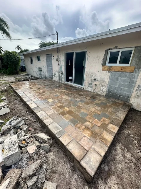 Raised paver patio nearly complete behind a house mid-renovation, Miami, FL