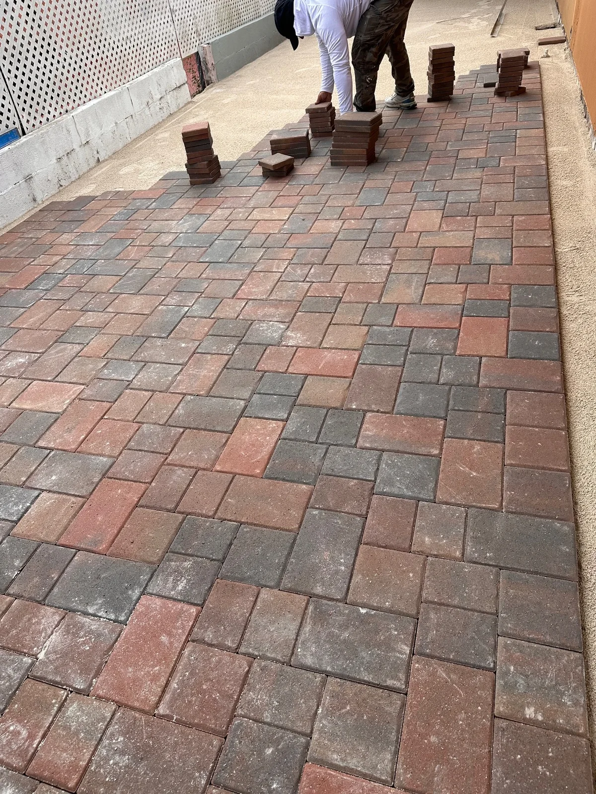 Red and charcoal pavers going down in a three-piece pattern next to the house, Miami, FL