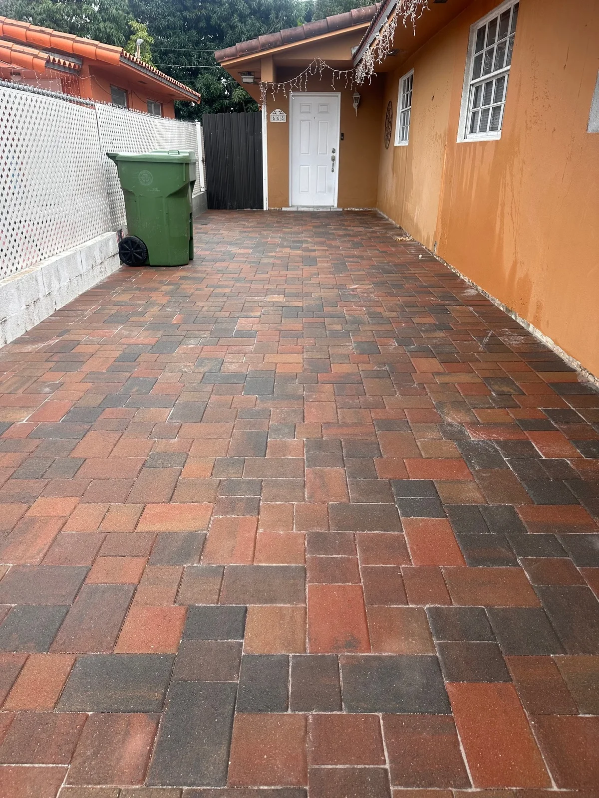 Red-blend pavers along the side yard leading to a back door, Miami, FL