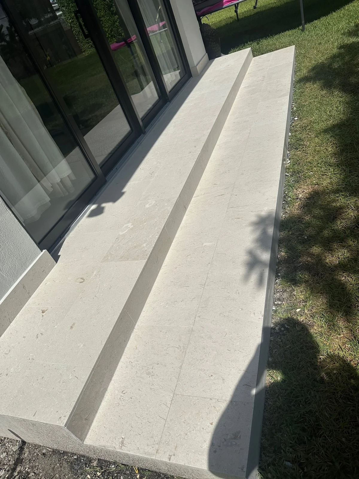 Travertine tile laid over a two-tier back step outside sliding doors, Miami, FL